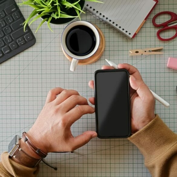 elinde telefon ve kalem tutan çocuk